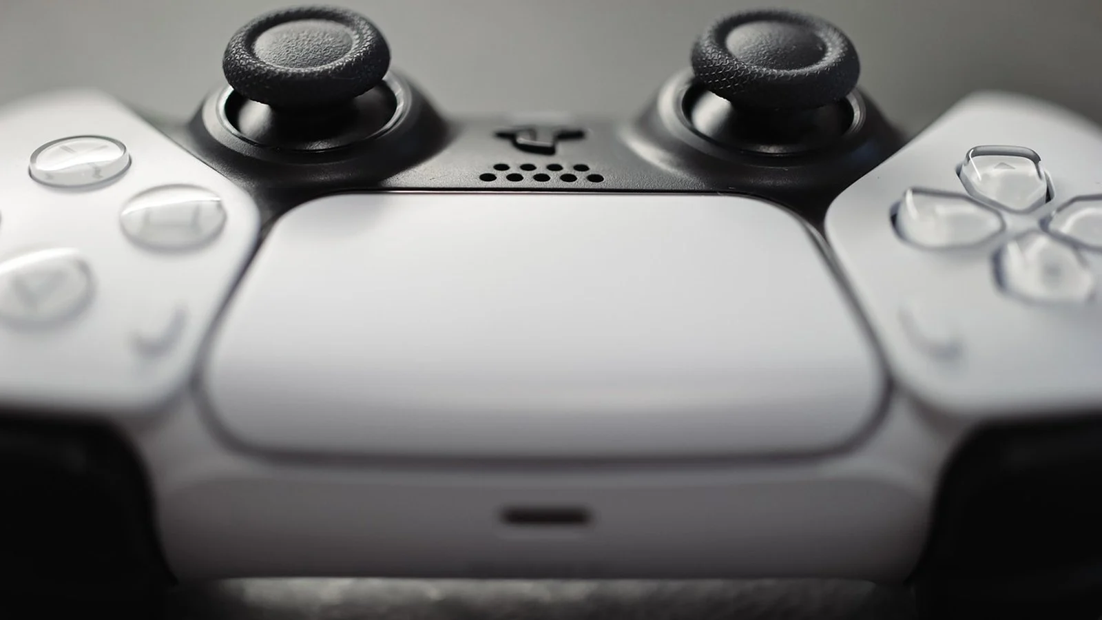 Close-up of a white PlayStation DualSense controller's touchpad and analog sticks