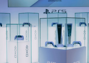 PS5 consoles and DualSense controllers displayed in glass cases at a PlayStation exhibit