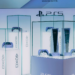 PS5 consoles and DualSense controllers displayed in glass cases at a PlayStation exhibit