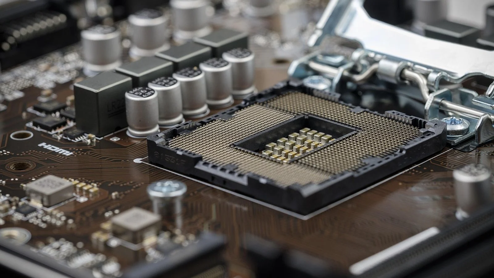 Empty CPU socket with open retention bracket on a motherboard, no processor installed