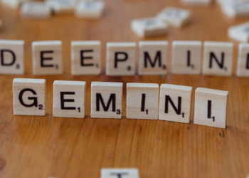 Wooden Scrabble tiles spelling DEEPMIND and GEMINI on a wood table