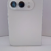 back of a white smartphone standing upright with a pill-shaped dual-camera module and flash