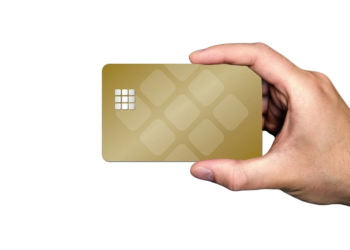 Hand holding a blank gold bank card with a decorative chip pattern against a white background