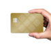 Hand holding a blank gold bank card with a decorative chip pattern against a white background