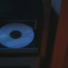 A blank CD-R disc sits in an open optical drive tray of a dark computer case