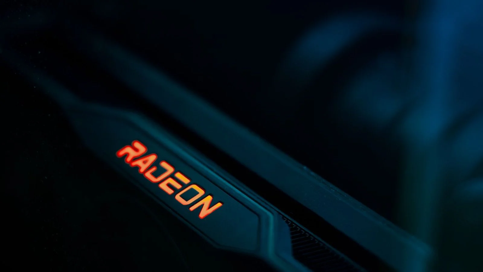 Close-up of a dark graphics card edge with an illuminated red-orange Radeon logo
