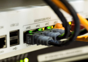 Rear panel of a networking device with USB, COM and ethernet ports connected to patch cables