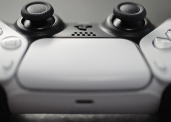 Close-up of a white and black PlayStation DualSense controller's touchpad and joysticks