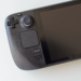 Close-up of a black Steam Deck handheld console's controls and screen, powered off