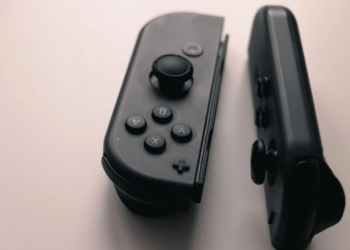 Two black Nintendo Switch Joy-Con controllers lying detached on a light surface