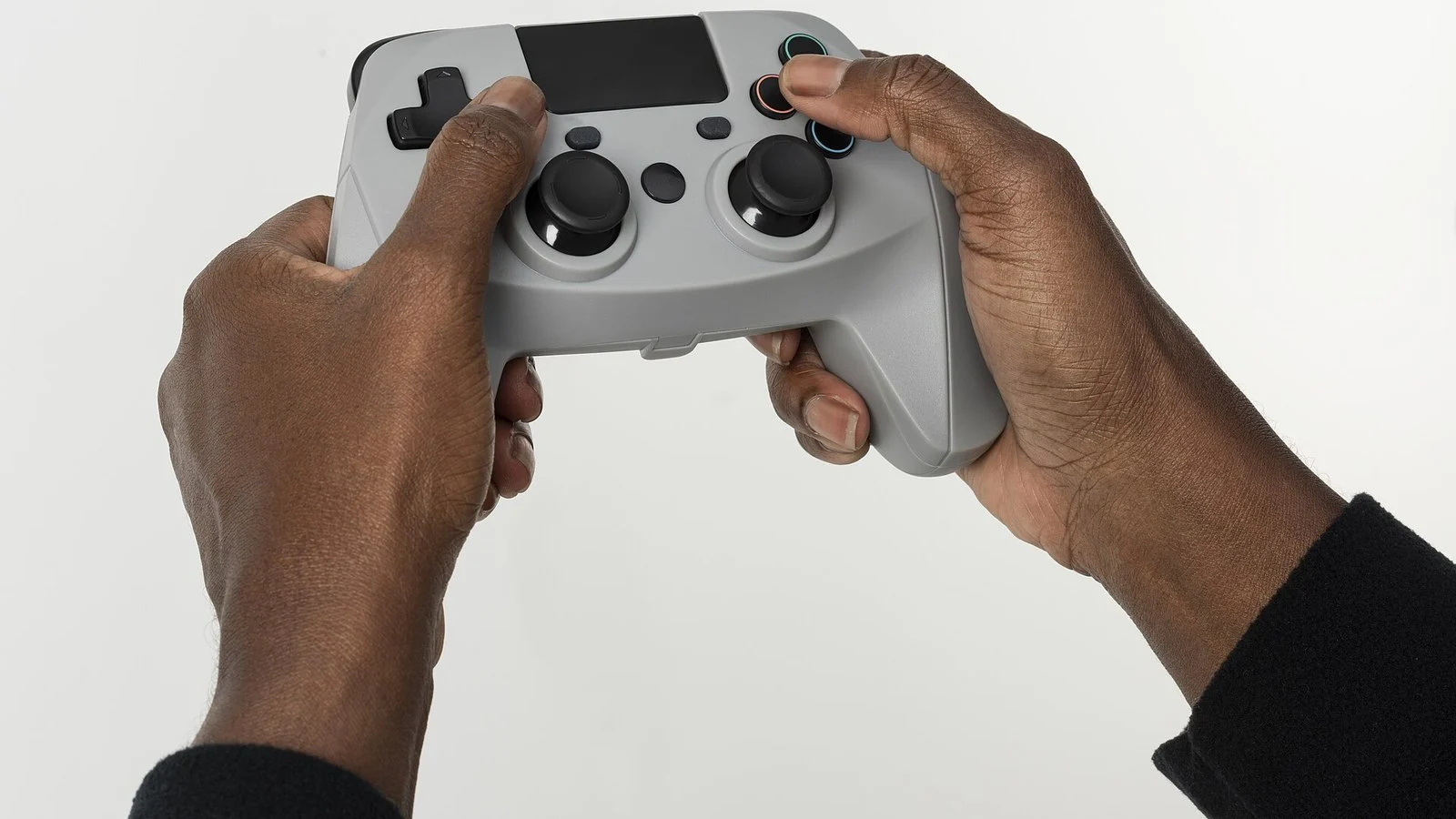 Hands holding a generic gray game controller against a white background