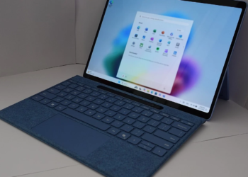 Silver 2-in-1 laptop with detachable tablet screen showing the Windows 11 Start menu on a blue background