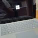 Surface laptop open on a wooden table, screen reflecting the person photographing it