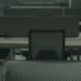 Empty office cubicles with unoccupied desk chairs and dividers in dim, greenish light