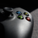 Close-up of a black Xbox controller's ABXY buttons and joystick on a fabric couch