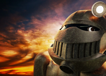 Weathered bronze robotic helmet with a circular lamp, lit against a dramatic sunset sky